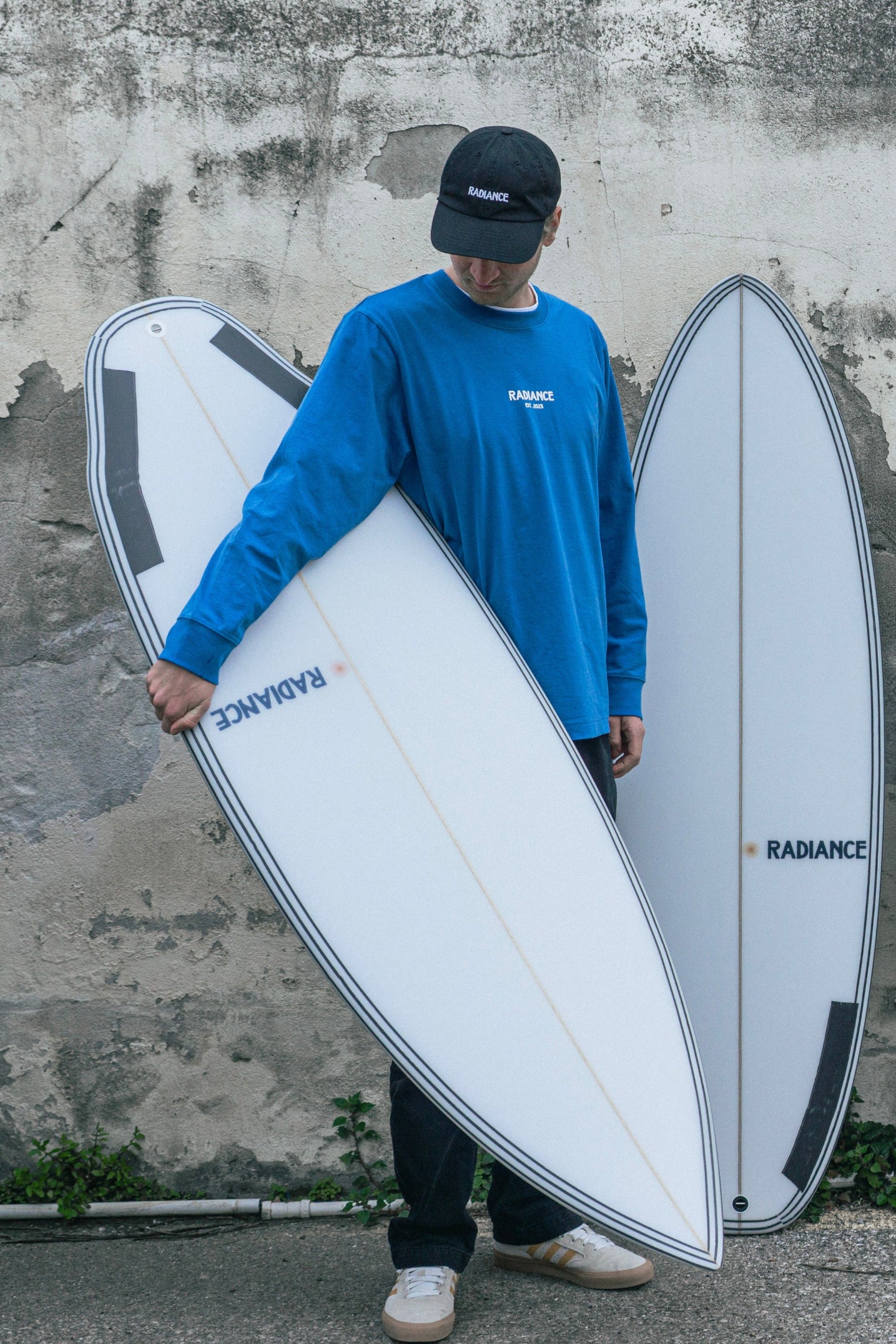 Guy holding a surfboard wearing Radiance Longsleeve blue