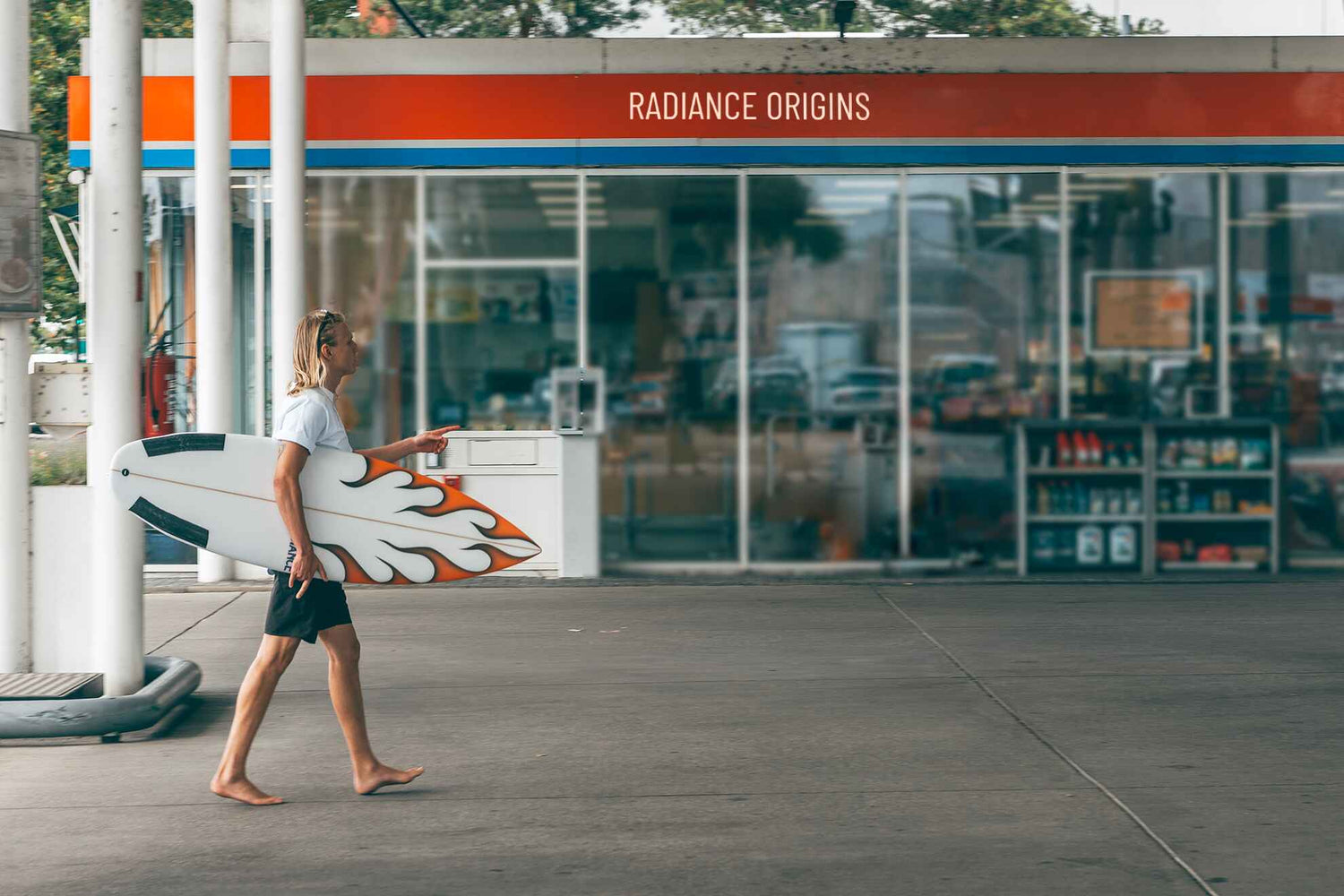 boy walking with heater riversurfboard at gas station
